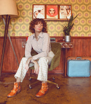 A woman sitting in a chair with an Oak Tree Farms Bady real leather suitcase.