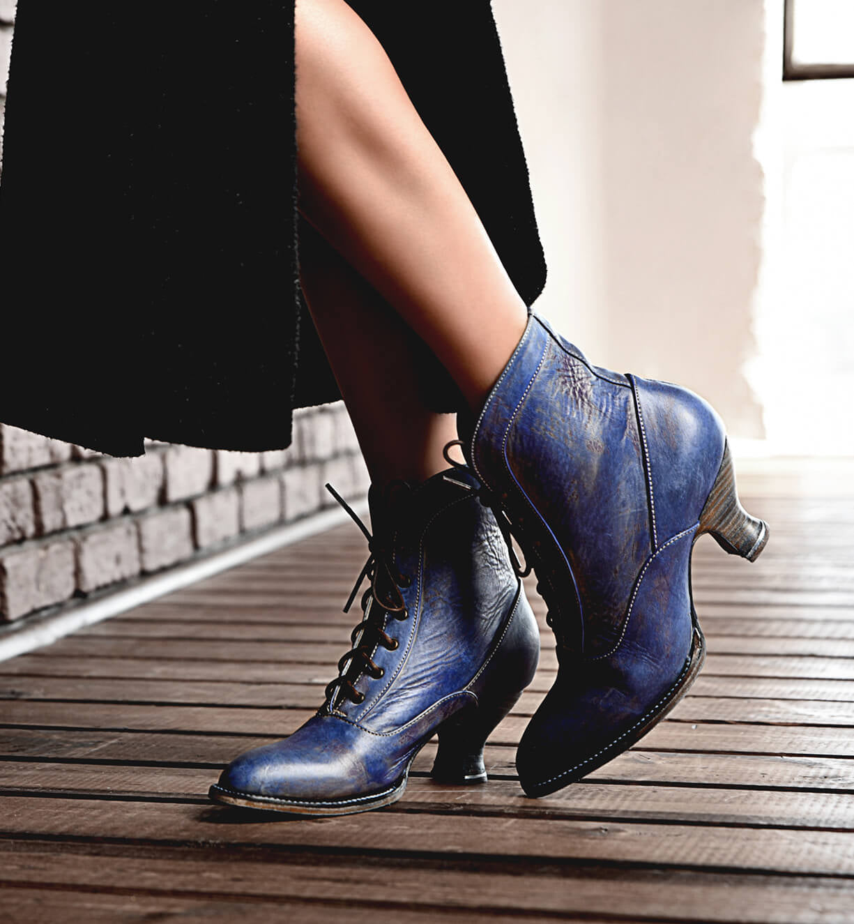 Oak Tree Farms Jacquelyn, a woman wearing handcrafted blue leather boots, showcases her fashionable footwear as she confidently walks across a wooden floor. The boots feature a leather welted outsole for added durability and.