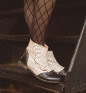 A woman wearing black stockings with YKK zipper standing on a stair wearing Josephine stockings by Oak Tree Farms.