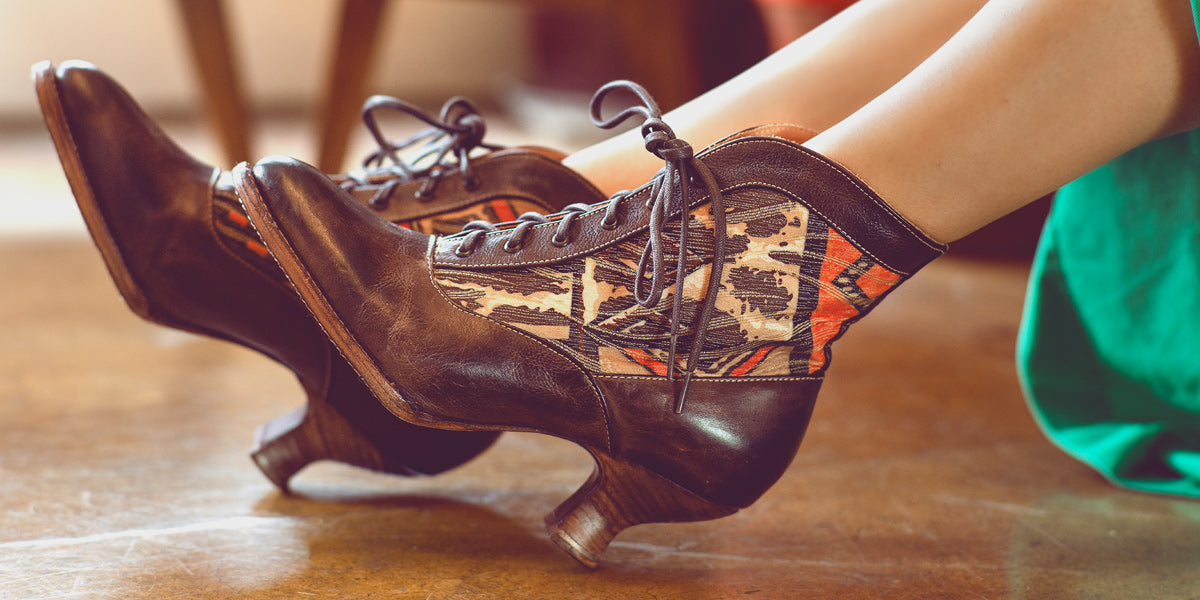 A woman's legs are sitting on a wooden floor.