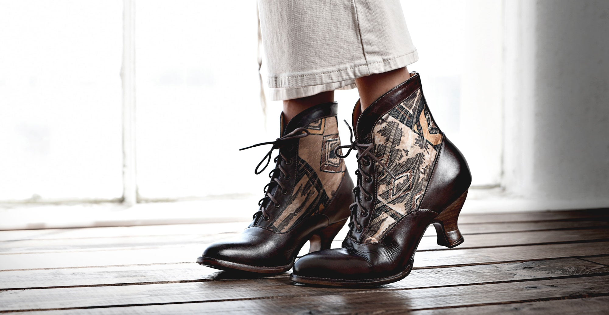 A woman wearing a pair of boots with tattoos on them.