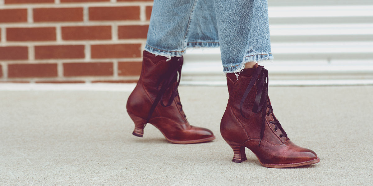 A woman wearing a pair of brown lace up boots.