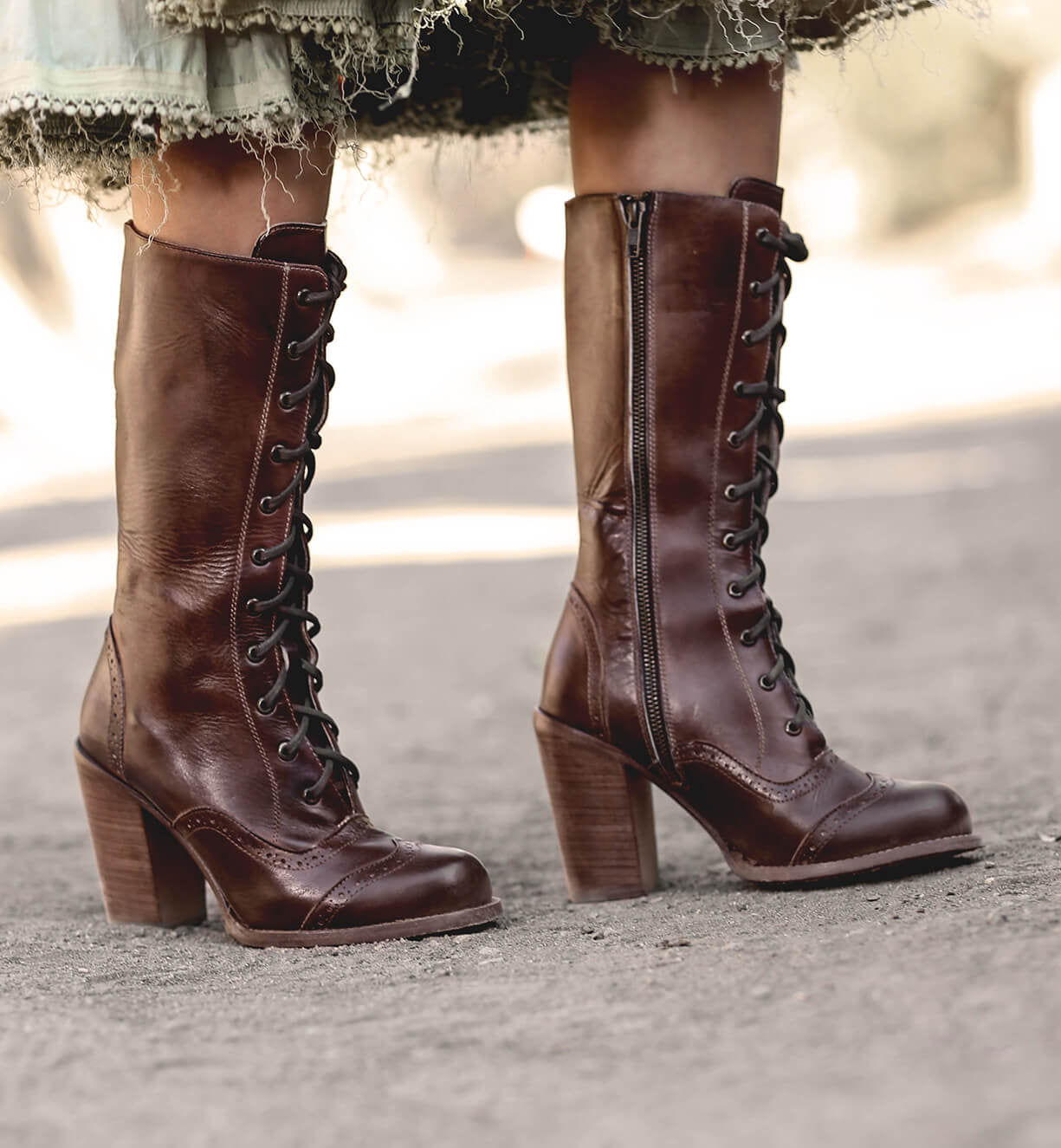 A woman wearing Oak Tree Farms' Ariana leather boots and a skirt.