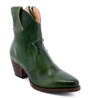 A green Baila cowboy boot with a wooden heel, made by Oak Tree Farms.