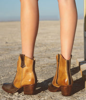 A woman wearing Baila cowboy boots by Oak Tree Farms in the desert.