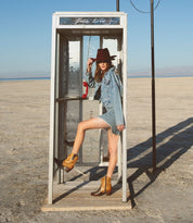 A woman posing in front of a Oak Tree Farms telephone booth.