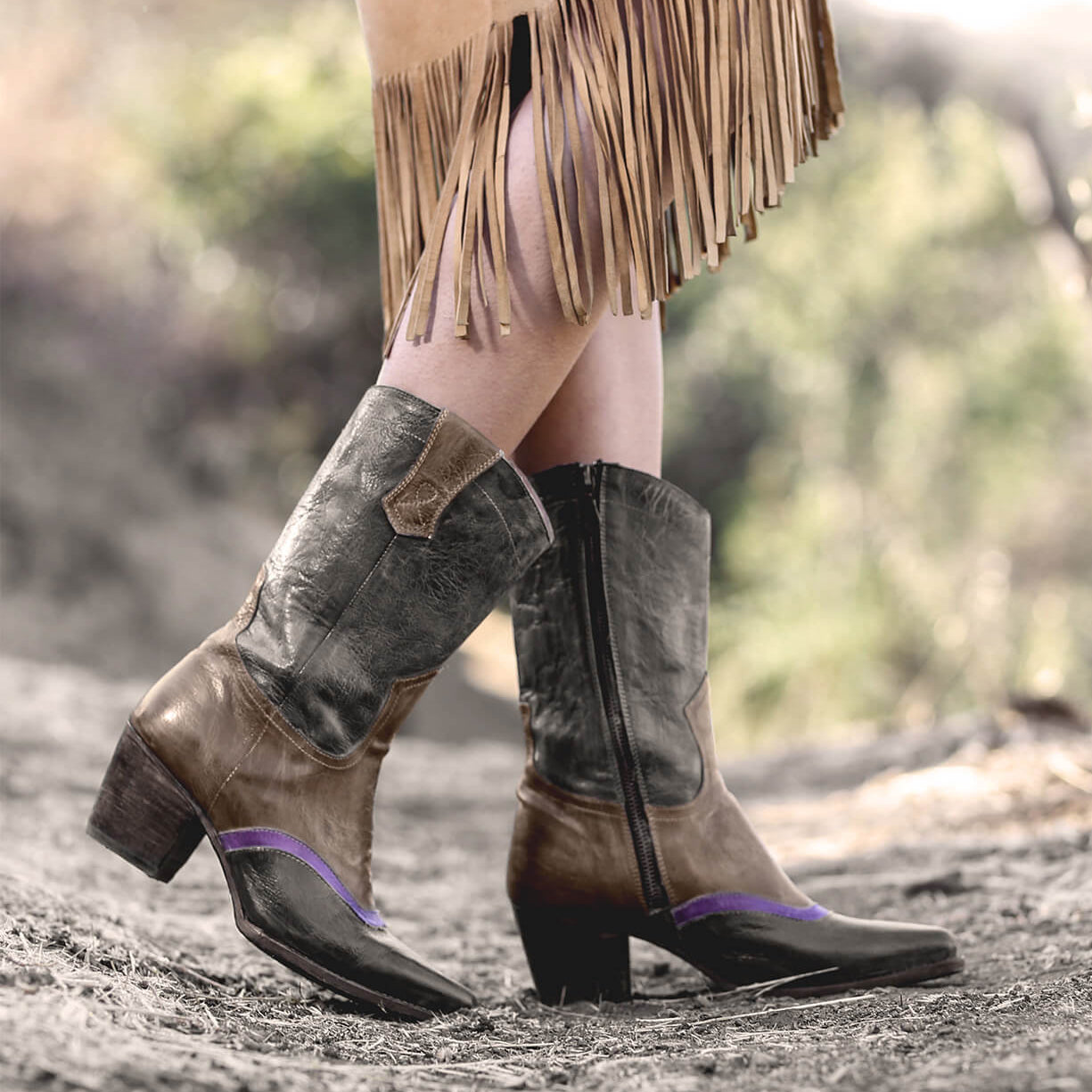 Oak Tree Farms Basanti, a woman wearing hand tooled leather cowboy boots and a fringe skirt.