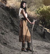 Oak Tree Farms, a woman in a cowboy outfit, holding a stick while donning leather boots.