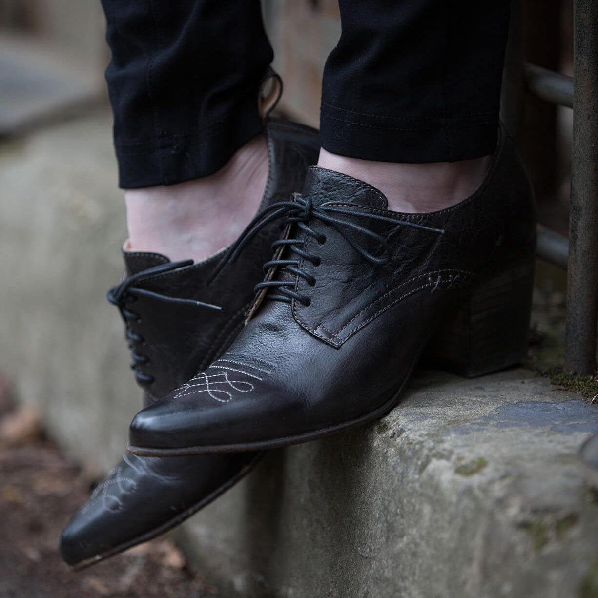 A person wearing Oak Tree Farms Braunstone dress shoes standing on a ledge.
