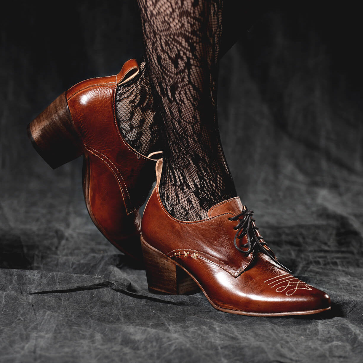 A woman wearing lace stockings and a pair of Oak Tree Farms Braunstone oxford dress shoes with a Victorian inspired silhouette.