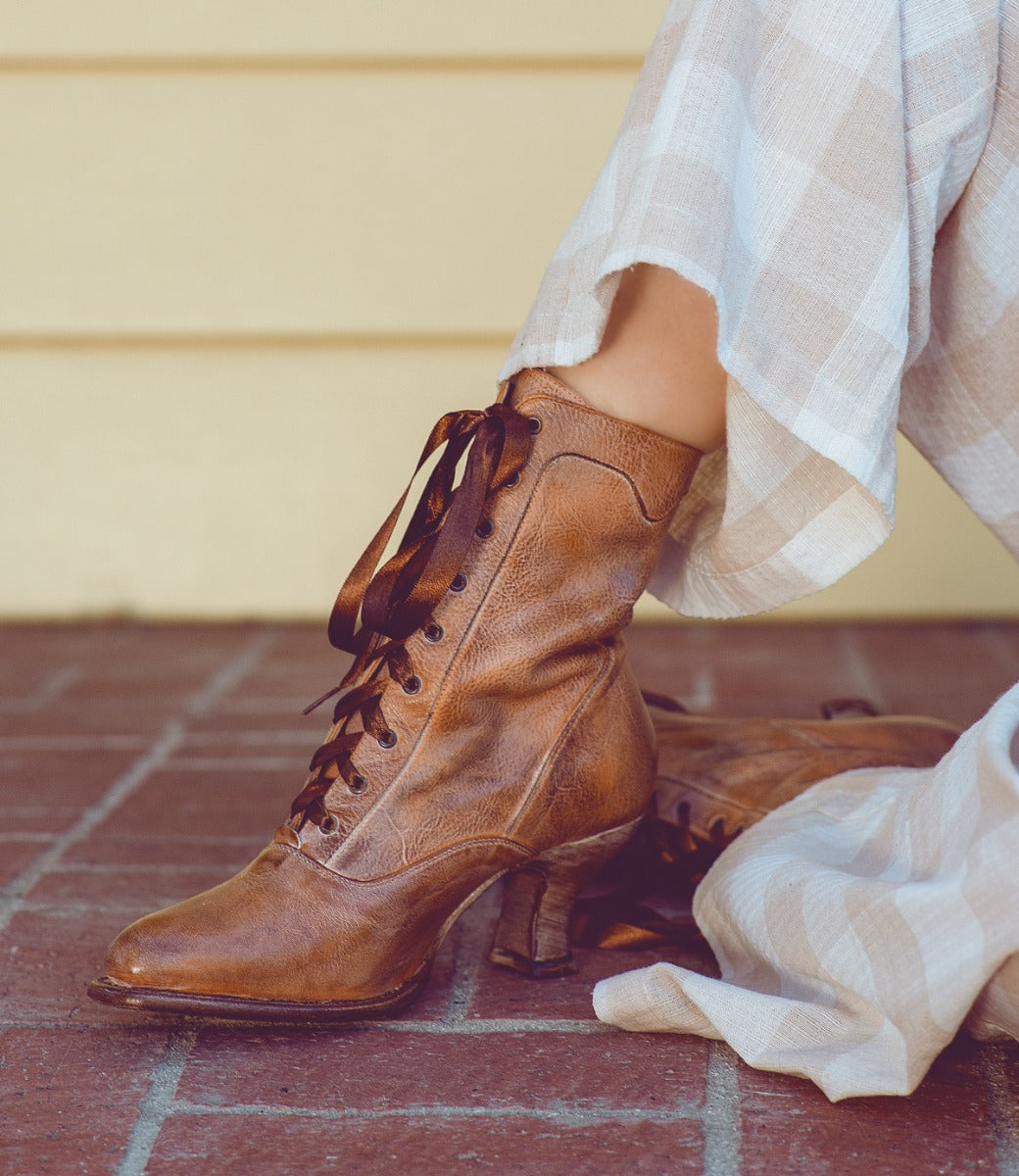 A woman showcasing her impeccable taste in Oak Tree Farms' Eleanor lace-up boots with a touch of Victorian style.