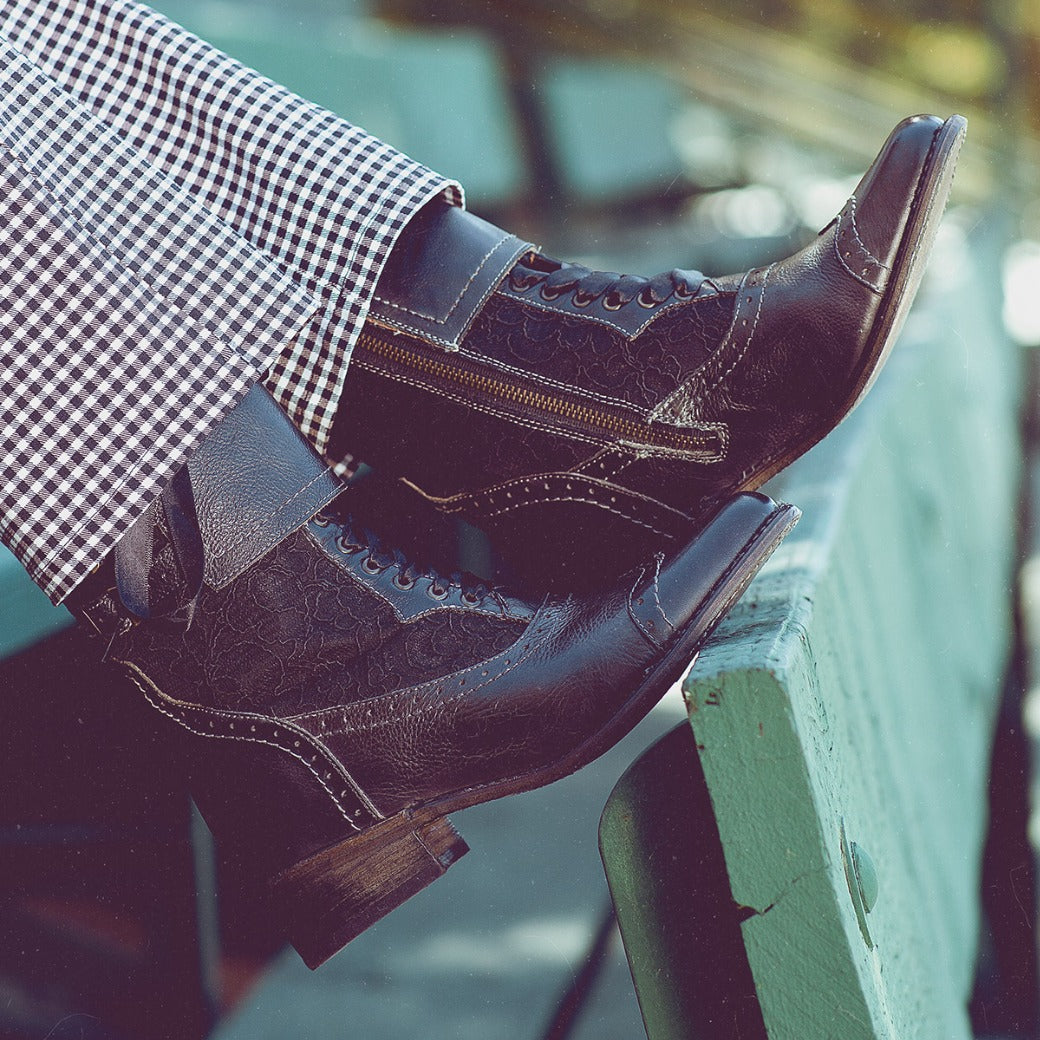 Oak Tree Farms’ Faye handcrafted leather riding boot rests on a bench.