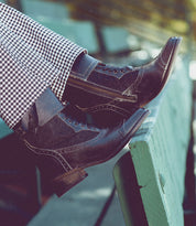 Oak Tree Farms’ Faye handcrafted leather riding boot rests on a bench.