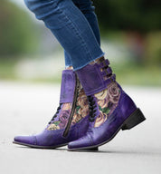 Oak Tree Farms Faye, a woman wearing handcrafted leather riding boots in purple with flower details.
