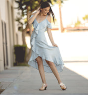 A woman wearing the Oak Tree Farms Janet dress and leather sandals with a lace-up front, creating a neutral look.