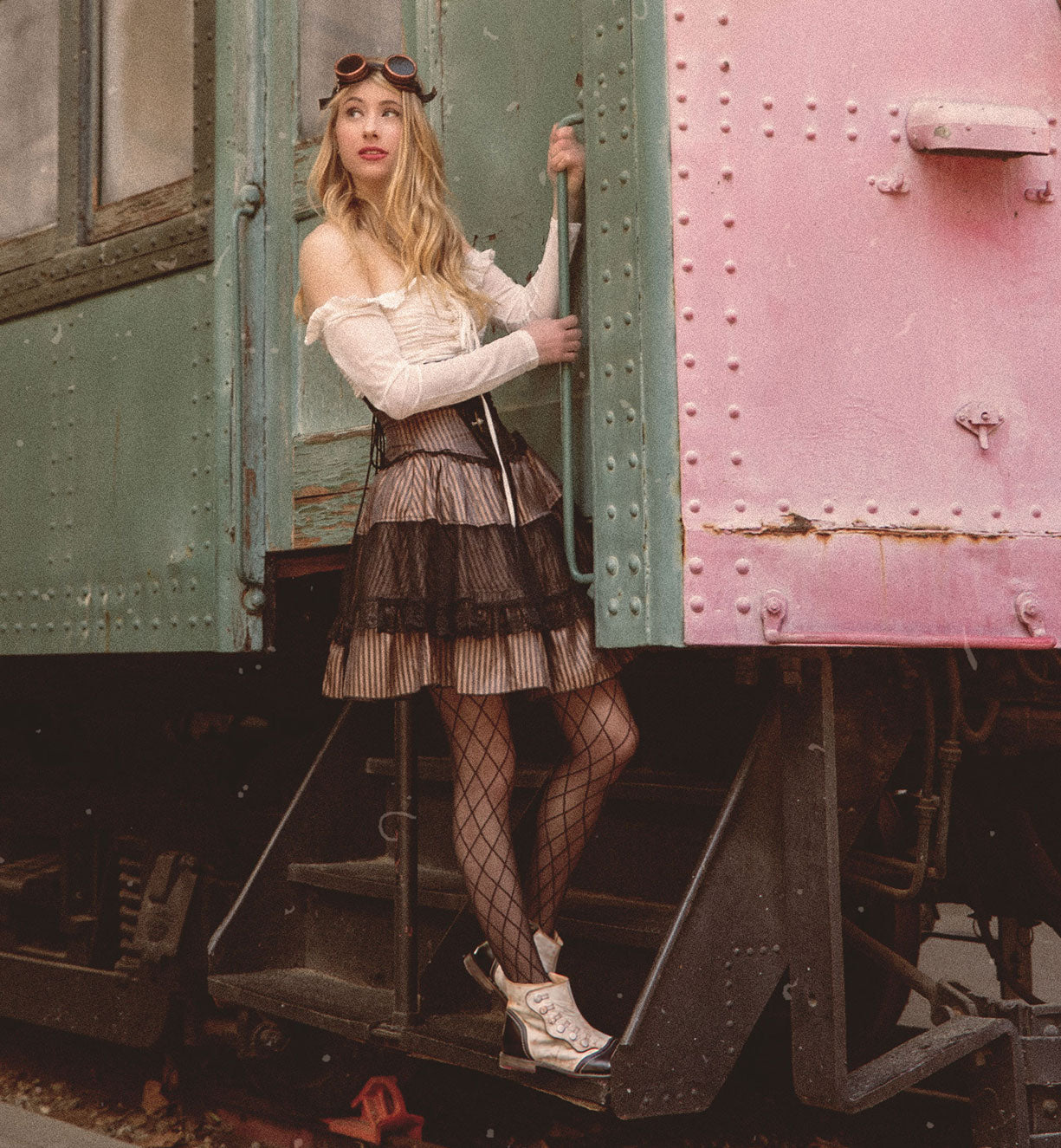 A woman is standing on the side of a train car wearing Oak Tree Farms Josephine leather booties.