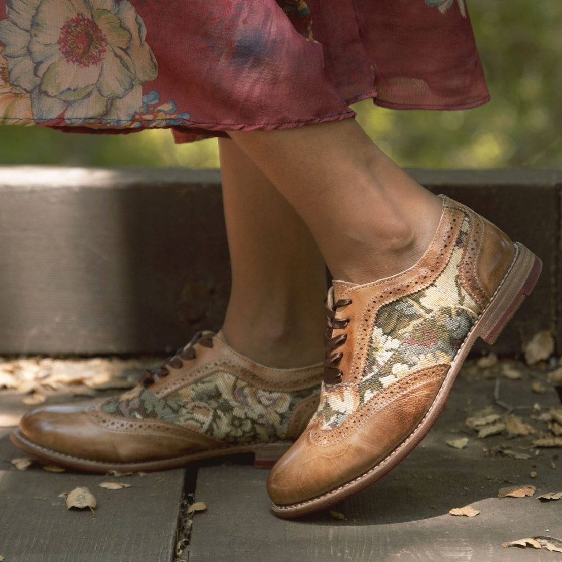 A woman displaying her Oak Tree Farms Maude leather wingtip oxford shoes in a comfortable floral dress.