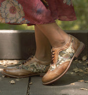 A woman displaying her Oak Tree Farms Maude leather wingtip oxford shoes in a comfortable floral dress.