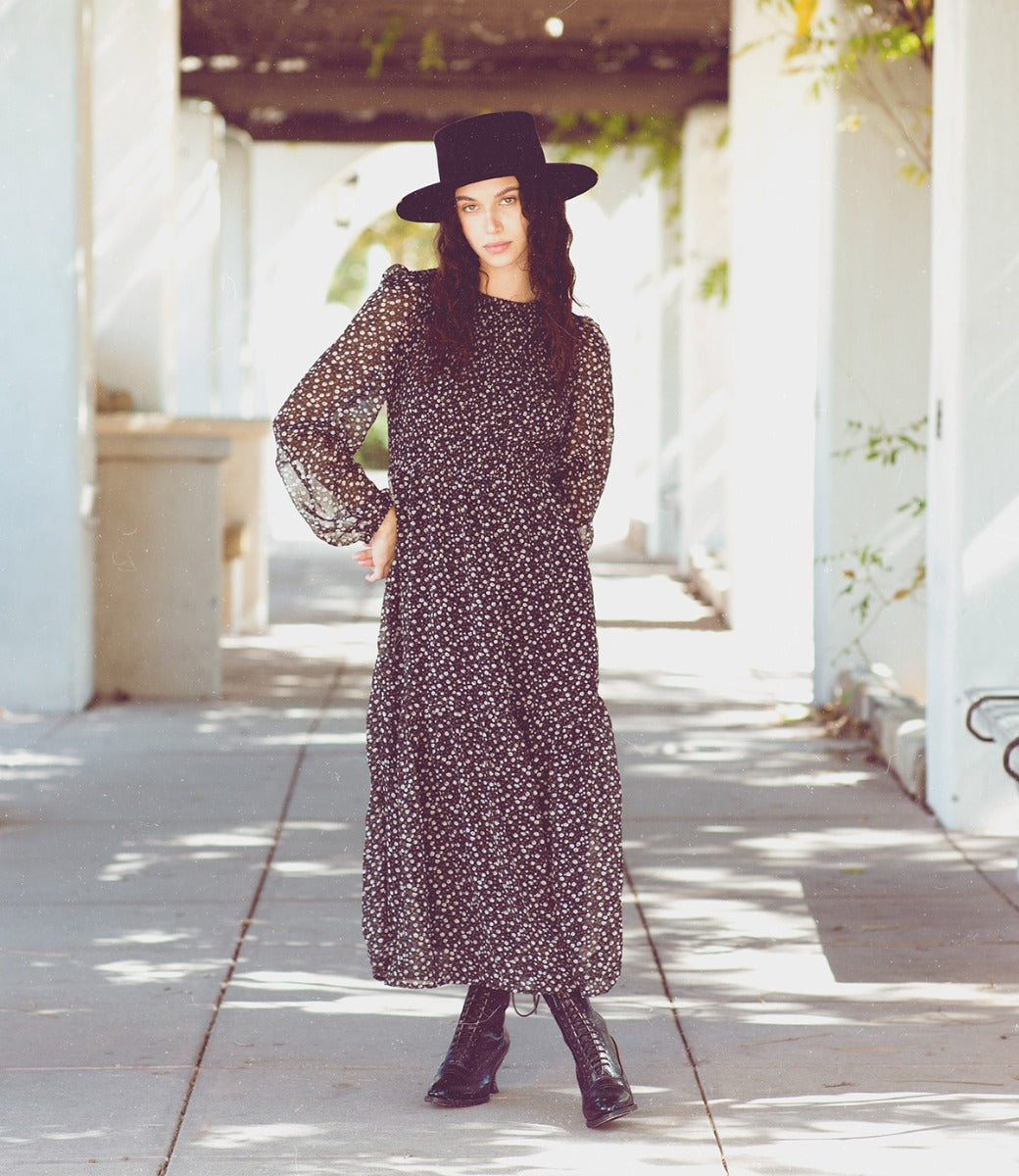 Oak Tree Farms, a woman wearing a black hat and dress, stepped out in style with her Mirabelle leather boots featuring grommet laces.