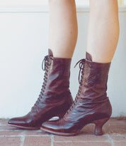 Oak Tree Farms' Mirabelle legs adorned with grommet laces on her brown leather boots.