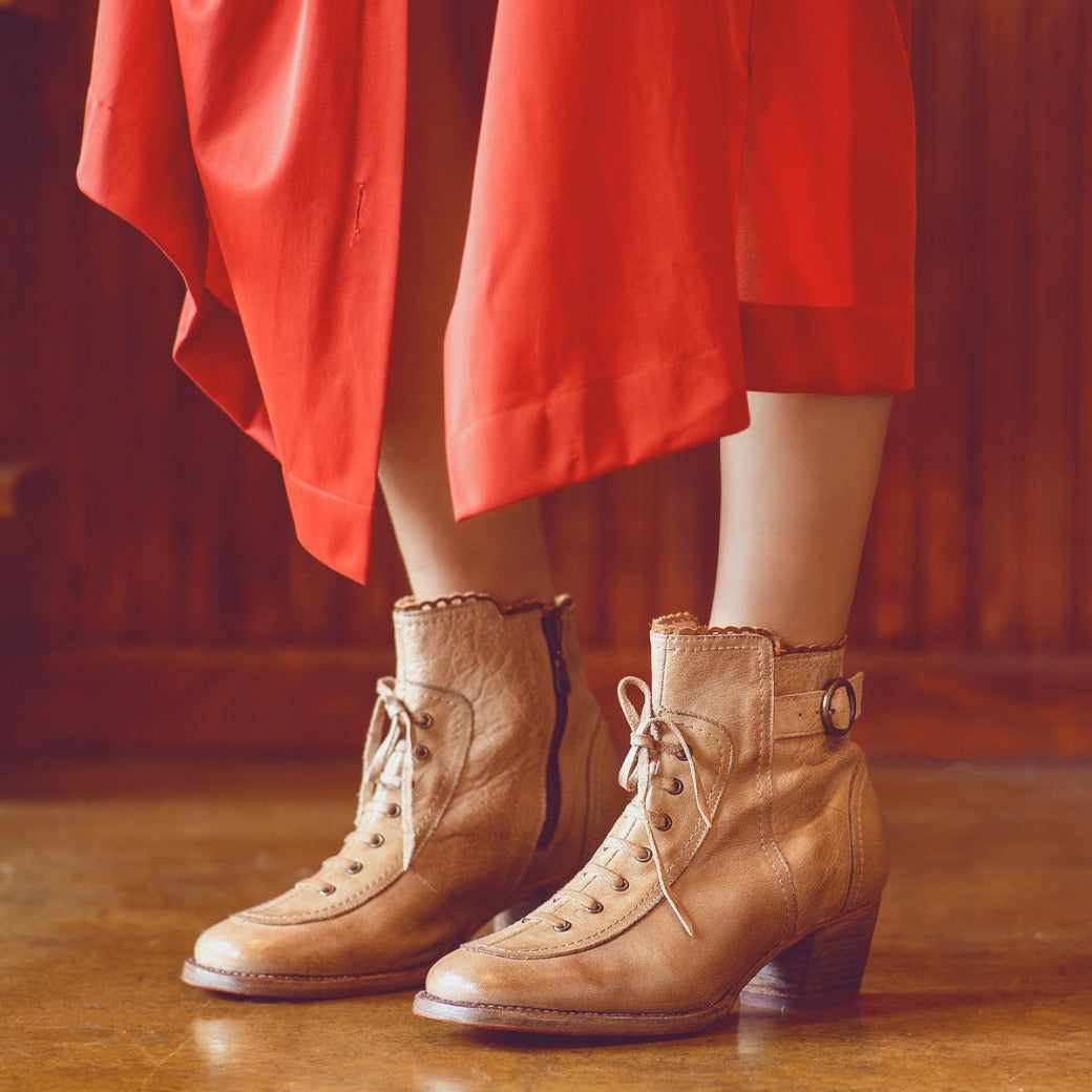 A leader dressed in an Oak Tree Farms red dress and wearing Oak Tree Farms tan leather heeled boots.