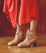 A leader dressed in an Oak Tree Farms red dress and wearing Oak Tree Farms tan leather heeled boots.