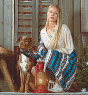 A woman with a dog, holding the Oak Tree Farms Maude lantern for comfort during her evening walk.